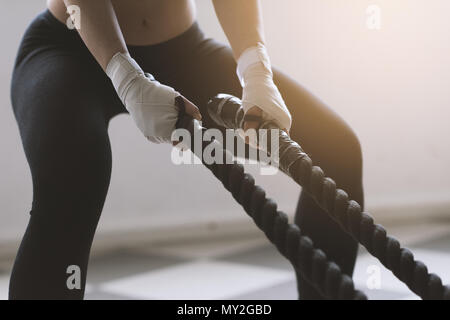 Junge sportliche Frau kämpfen Seil Ausbildung, sie schwingt das Seil, Hände, Nahaufnahme Stockfoto