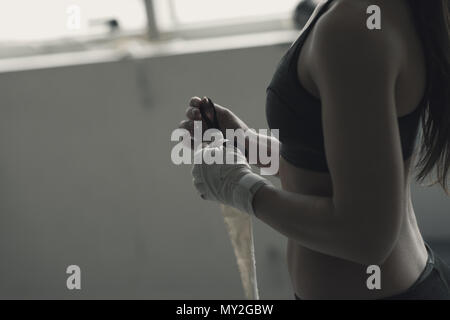 Boxer Frau ihre Handgelenke und Hände wickeln mit schützenden verband, sie ist eine Ausbildung bei der Boxing Club Stockfoto