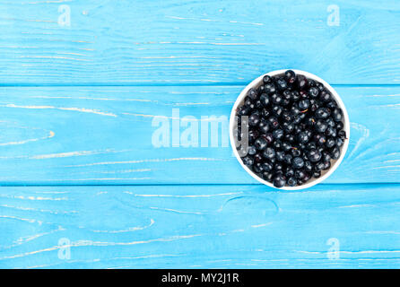 Weißer Keramik Schüssel voll mit frischen Blaubeeren auf eine leere Tabelle, Ansicht von oben Stockfoto