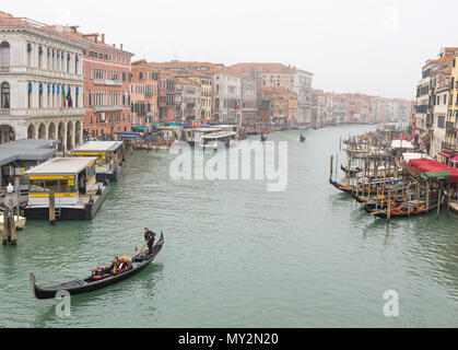 Venedig Italien - Oktober 18, 2017 Venezianische Gondoliere stochern Gondel durch Kanal Wasser von Venedig Italien an einem nebligen Tag und Regen, Gondeln in Venedig, ICH Stockfoto