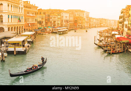 Venedig Italien - Oktober 18, 2017 berühmten Venezianischen Gondoliere stochern Gondel durch Kanal Wasser von Venedig Italien mit Sonnenuntergang, Gondeln in Venedig, Italien. Stockfoto
