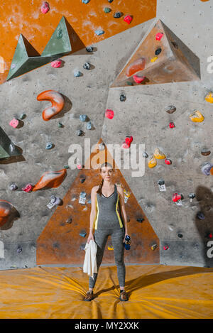 In voller Länge für eine junge Frau in sportliche Kleidung vor der Kletterwand posing Stockfoto