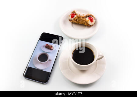 Bild Kaffee und süßes Cookie mit einem Smartphone in den weißen Hintergrund. Stockfoto