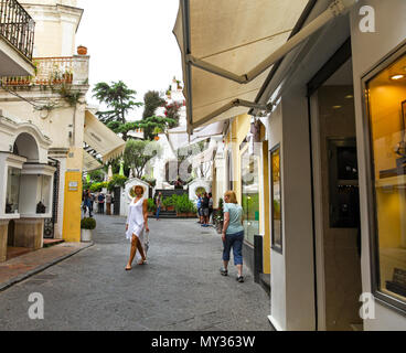 Eine elegante Dame flanieren durch die Via Camerelle, einer teuren, up-market Shopping Street, wo Sie Designer Labels auf der Insel Capri, Italien zu verkaufen Stockfoto