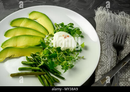 Pochierte Eier mit Gemüse, Avocado grüne Bohnen und Salat. Die Aussicht von oben. Natürliche Lebensmittel. Stockfoto