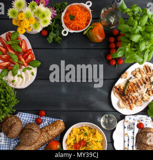 Eine Menge gleich Essen auf den Tisch, Italienische Caprese Salat, gegrillten Fisch, Salat und Blumen. Ein gesundes und gesundes Mittagessen für die ganze Familie. Platz kopieren, oben, flach. Stockfoto
