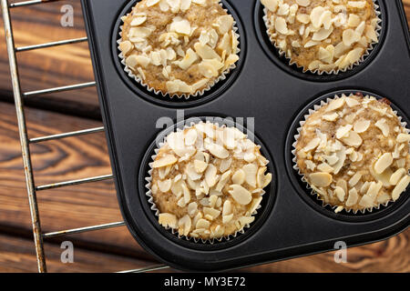 Hausgemachten blueberry muffins mit Mandel in bran Backgeräte auf broun Holz- Hintergrund Stockfoto