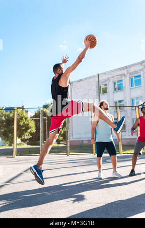 Basketball Spieler fangen Ball beim Basketball spielen mit Team Stockfoto