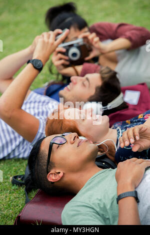 College Freunde zusammen Entspannen auf Gras Stockfoto