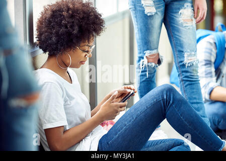 Studentin Sie Ihr Smartphone während der Pausen in der Schule Stockfoto