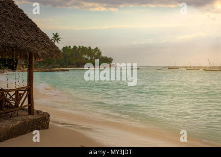 Ein schöner Strand mit mehreren Fischerboote bei Sonnenuntergang mit Sonnenstrahlen verankert. Sansibar, Tansania. Stockfoto