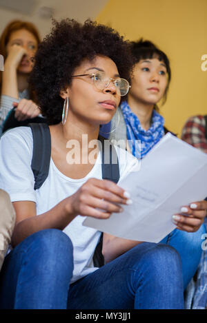 Den Studenten im Treppenhaus sitzen Stockfoto