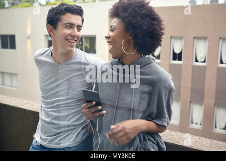 Junges Paar Musik hören zusammen auf smart phone Stockfoto
