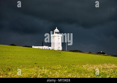 South Forland Leuchtturm, auf Klippen von Dover in schwarzen Gewitterwolken. Helles, weißes Gebäude, das sich gegen die dunklen heavy rain Cloud. Kent, Großbritannien Stockfoto