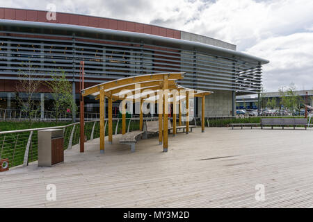 Überdachte Sitzecke auf einem Holzsteg mit einigen moderne Architektur in den Hintergrund; Rushden Seen, Northamptonshire, Großbritannien Stockfoto