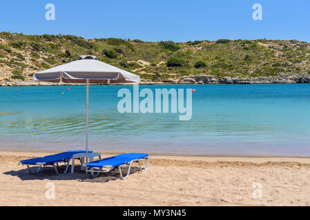 Liegestühle mit Sonnenschirm auf schönen sandigen Strand von Kolymbia. Die Insel Rhodos, Griechenland Stockfoto