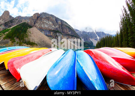 Fischaugenobjektiv, einer Reihe von Kanus entlang der Ufer des Lake Moraine Lake Louise in der Nähe von Banff in den kanadischen Rockies, mit schweren Wolken absteigend auf t Stockfoto