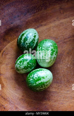 Cucamelons sind ordentlich auf einem Tisch angeordnet und präsentieren ihr einzigartiges Aussehen und ihre Frische, die die Zuschauer einladen, ihren köstlichen Geschmack zu genießen. Stockfoto