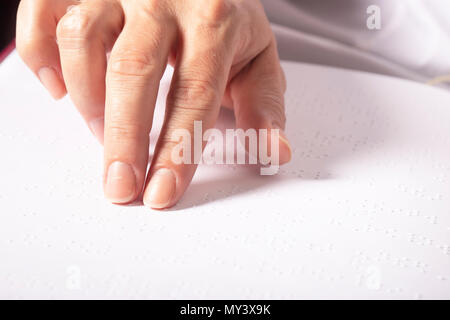 Blinde Frau lesen Buch in Blindenschrift geschrieben. Close up Finger berühren zu Braille Stockfoto