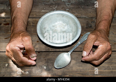 Hände die armen alten Mann's und leere Schüssel auf Holz Hintergrund. Das Konzept der Hunger oder Armut. Selektive konzentrieren. Armut im Ruhestand. obdachlos. Almosen Stockfoto