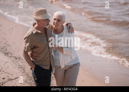 Gerne älteres Paar umarmt am Sandstrand Stockfoto