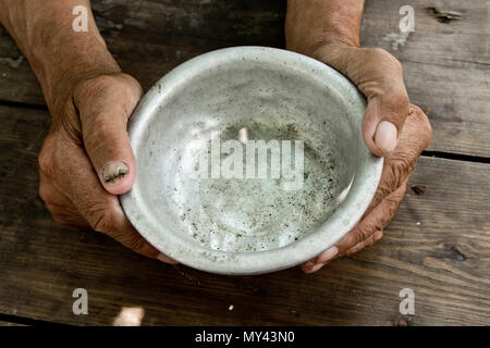 Die Hände des armen alten Mann eine leere Schale, Sie um Hilfe zu bitten. Das Konzept der Hunger oder Armut. Selektive konzentrieren. Armut im Ruhestand. Almosen Stockfoto