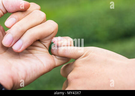 Versprechen Konzept. Nahaufnahme, Hände von Paar Anspannen des jeweils anderen kleinen Finger zusammen. Stockfoto