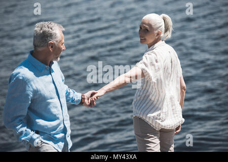 Casual ältere Paare, Hände auf Riverside tagsüber Stockfoto