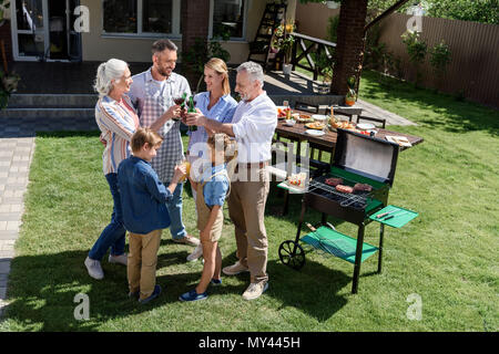 Glückliche Familie von drei Generationen anstoßen und Grill Stockfoto