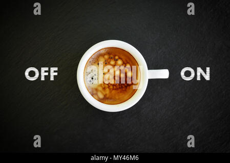 Espresso in kleine weiße Tasse mit Schriftzug 'on' und 'off' auf schwarzem Schiefer Hintergrund, Ansicht von oben Stockfoto