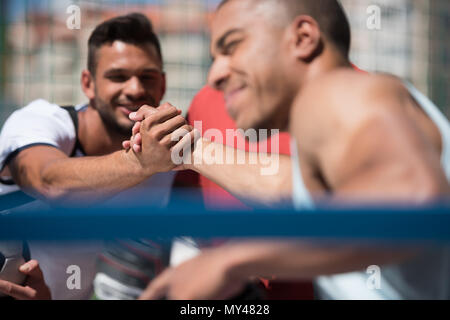 Selektiver Fokus der multikulturellen Männer sitzen auf Stadium vor dem Training Stockfoto