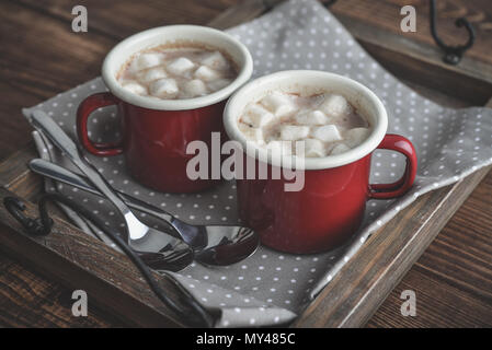 Zwei metall Becher Kakao mit Marshmallows auf Fach über Holz- Hintergrund Stockfoto