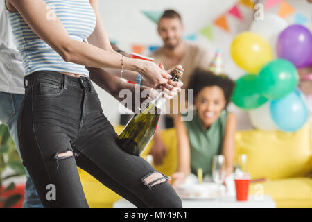 Nahaufnahme der Mann hilft Frau Eröffnung Champagner zum Geburtstag Stockfoto