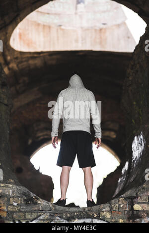 Rückansicht der Mann in Grau hoodie stehend auf Ruinen Stockfoto