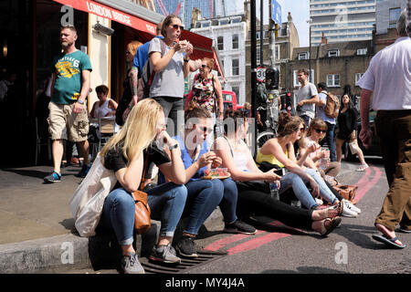 Frauen sitzen auf Kandare Essen, Borough Markt, Southwark, London, England Stockfoto