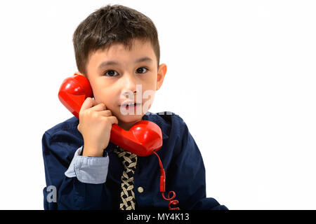 Studio shot der netten Jungen sprechen auf alten Telefon Stockfoto