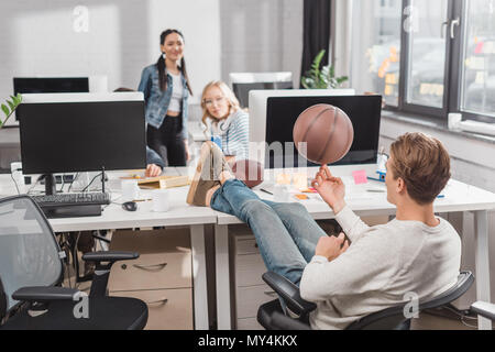 Frauen beobachten, bei der man sich drehende Kugel im Büro Stockfoto