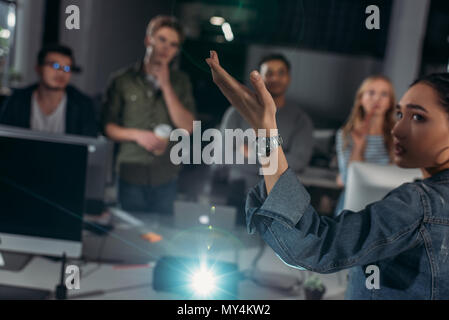 Junge Leute, die sich in modernen Büro-, Frau zeigt auf dem Bildschirm Stockfoto