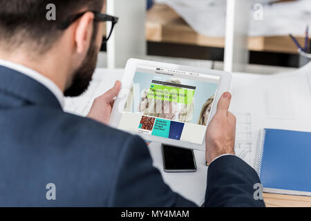 Geschäftsmann holding Tablet mit geladenen bbc Wissenschaft Seite Stockfoto