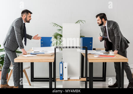 Zwei Geschäftsleute Streit über Partition im Büro Stockfoto