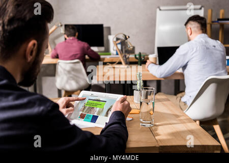 Geschäftsmann holding Tablet mit geladenen bbc Wissenschaft Seite Stockfoto