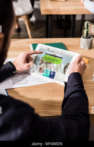 Zugeschnittenes Bild des Geschäftsmannes holding Tablet mit geladenen bbc Wissenschaft Seite Stockfoto