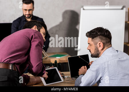 Geschäftsmann etwas an der Tafel zu Kollegen Stockfoto