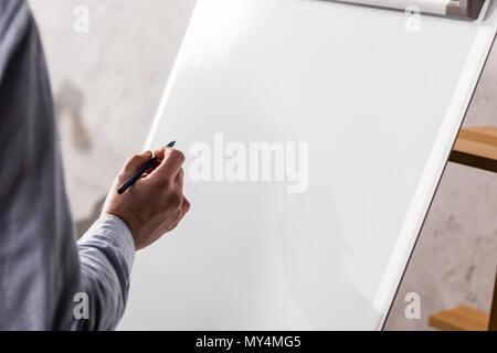 Zugeschnittenes Bild des Geschäftsmannes schreiben etwas auf Flipchart Stockfoto