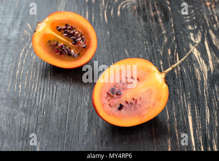 Zwei Hälften tamarillo Obst auf hölzernen Hintergrund close-up Stockfoto