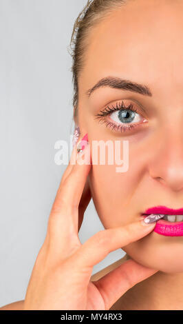 Die Hälfte des Gesichts des schönen Frau mit Make-up und Maniküre Stockfoto