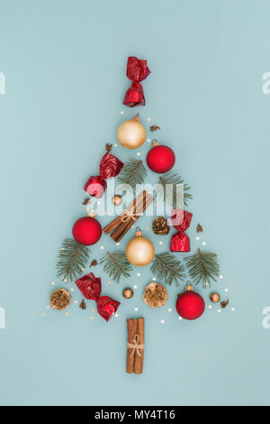 Festliche Weihnachten Baum des Neuen Jahres Dekorationen auf blauem Hintergrund. Zimt, Bonbons, Kugeln, Fichte, Kegel, goldfarbenen Pailletten im Urlaub Karte. Flach Stockfoto