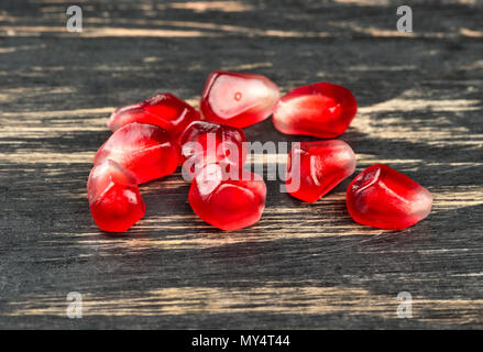 Reifer Granatapfel Samen verstreut auf einem hölzernen Hintergrund Nahaufnahme Stockfoto