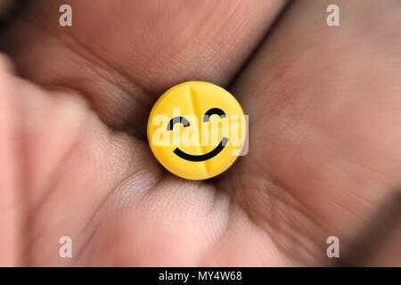 Pille mit smiley Logo in der Hand, Nahaufnahme Stockfoto