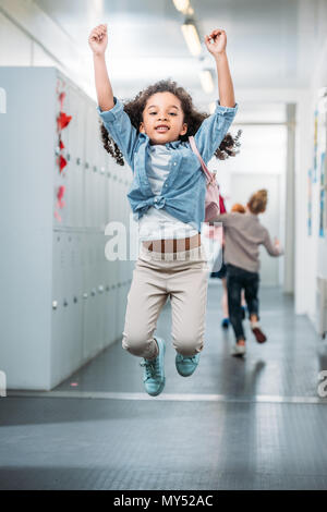 Kleine afrikanische amerikanische Mädchen in der Schule Flur springen Stockfoto